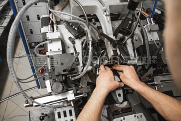 男人用特殊的機械工具制鞋。鞋廠的輸送機,有鞋底和鞋底。